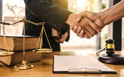 Van Gils Law Firm - Nonprofit / not-for-profit organization legal services - image shows handshake over paperwork